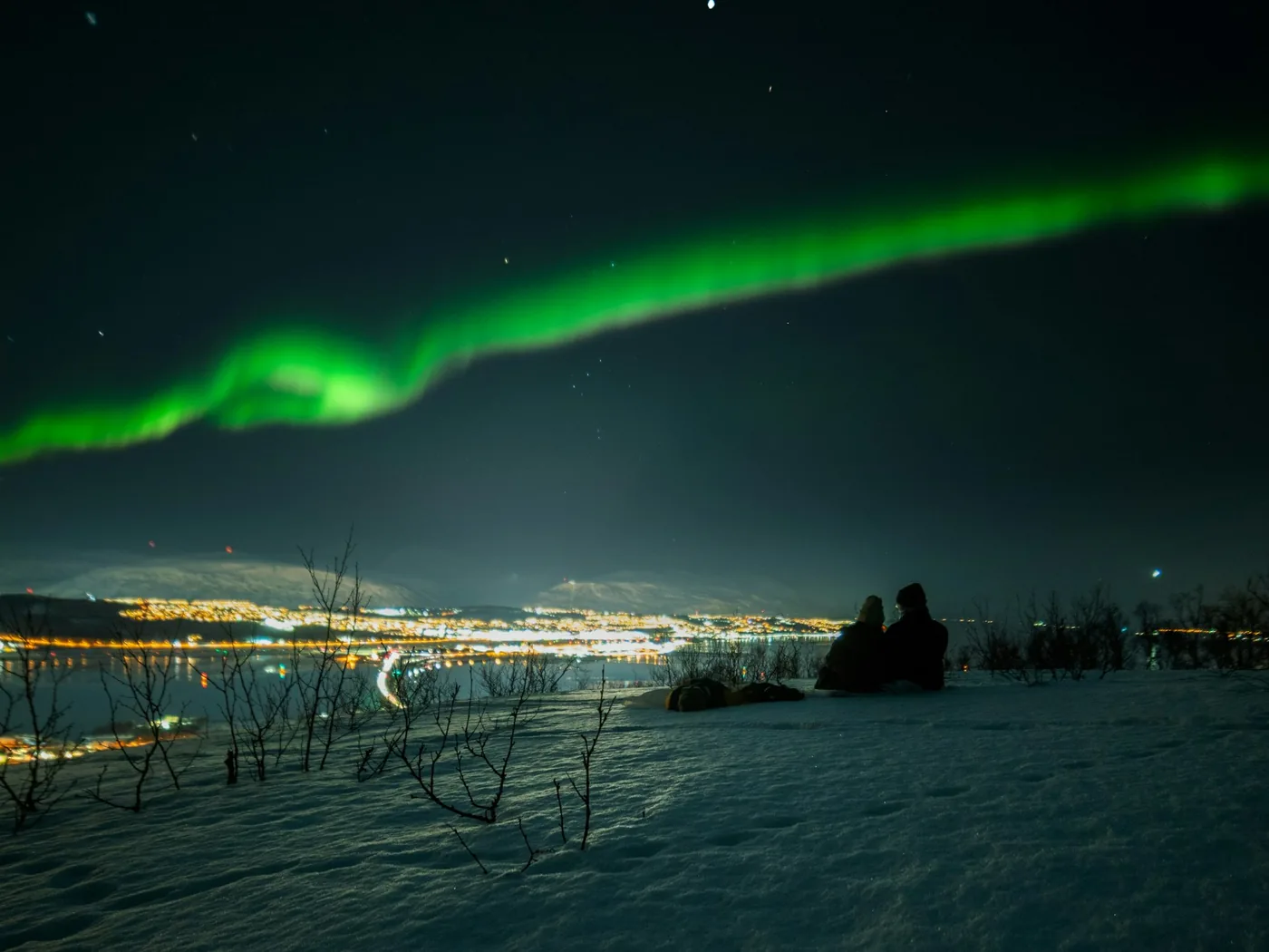 The lights of Tromsø between snowy peaks in the Arctic winter
